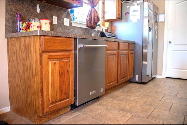 kitchen featuring tasteful backsplash, dark countertops, baseboards, stainless steel fridge with ice dispenser, and brown cabinets