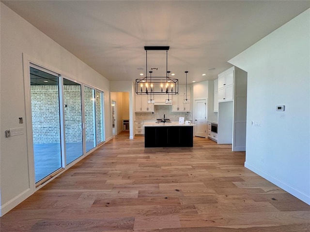 12812 Cobblestone Curve Rd, Oklahoma City, OK 73142 - kitchen featuring white cabinets, light countertops, light wood finished floors, and a notable chandelier