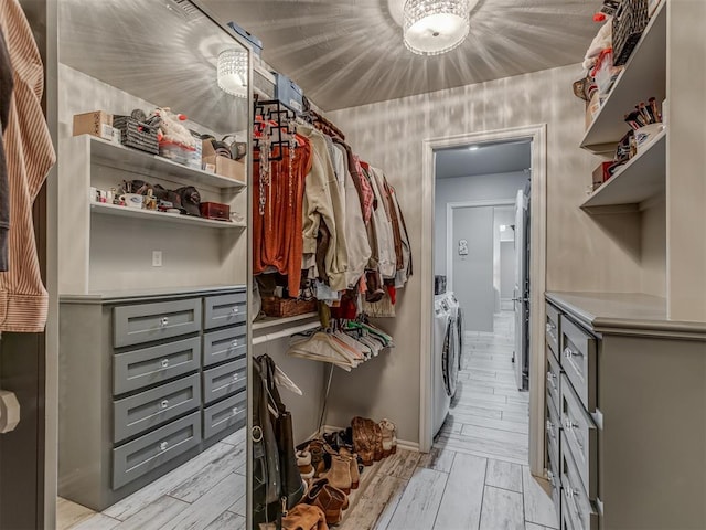 walk in closet featuring separate washer and dryer and wood finish floors