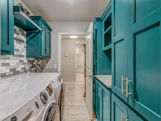 washroom with cabinet space, wood finish floors, and washing machine and clothes dryer