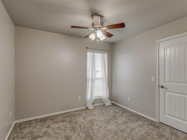 empty room with light carpet, ceiling fan, and baseboards