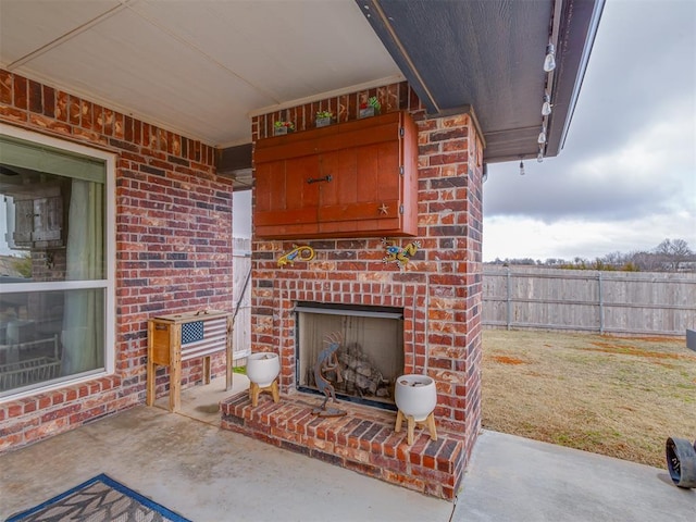 view of patio / terrace with an outdoor brick fireplace and fence