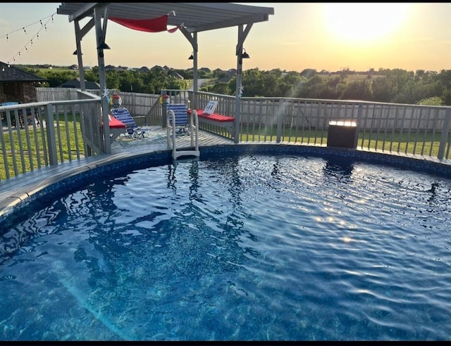 pool at dusk with a fenced in pool and a fenced backyard