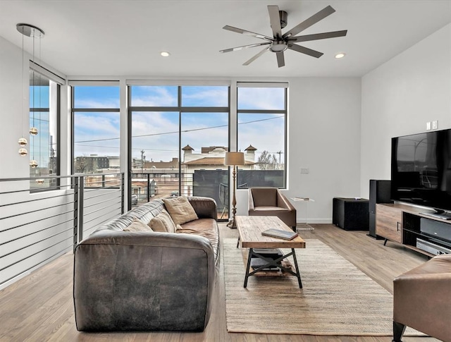 living room featuring plenty of natural light, a wall of windows, and light wood-type flooring