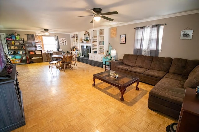 living room featuring light parquet floors, crown molding, a brick fireplace, and ceiling fan