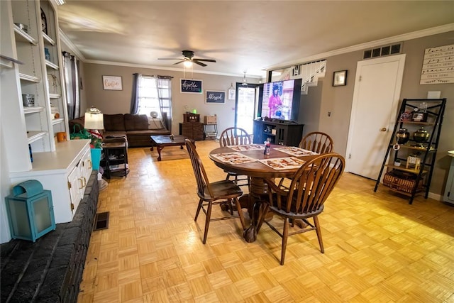 dining space featuring ornamental molding, light parquet flooring, and ceiling fan