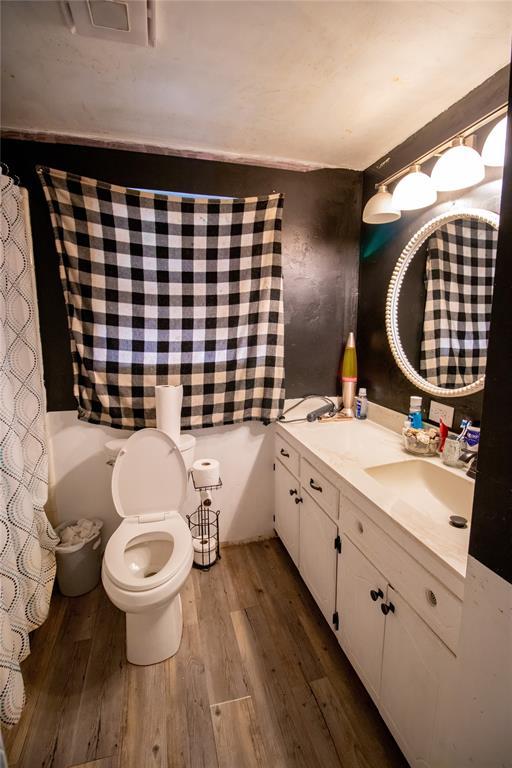 bathroom with vanity, toilet, and hardwood / wood-style floors