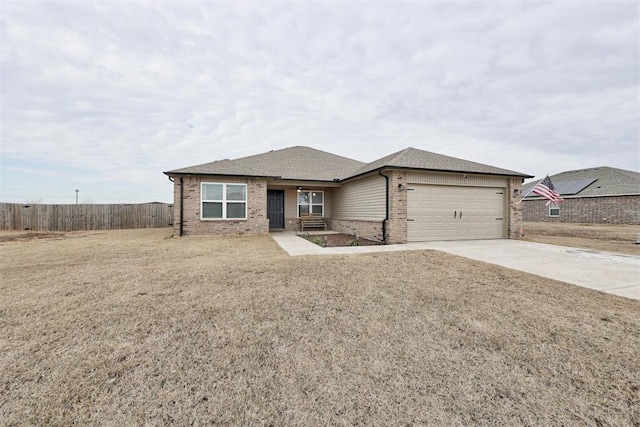 view of front facade featuring a garage, driveway, fence, a front lawn, and brick siding