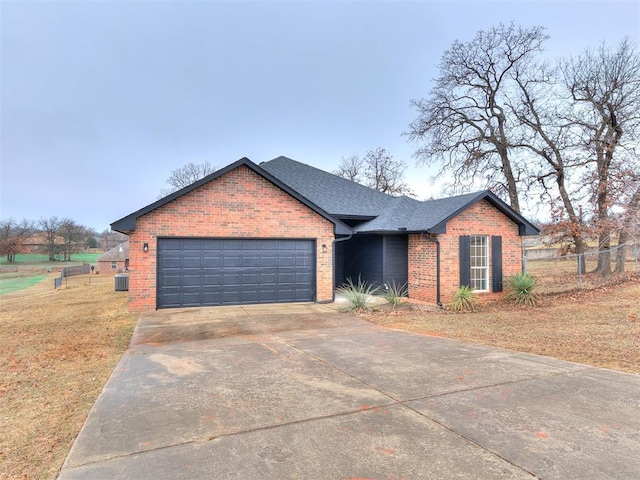 ranch-style home featuring an attached garage, brick siding, a shingled roof, fence, and concrete driveway