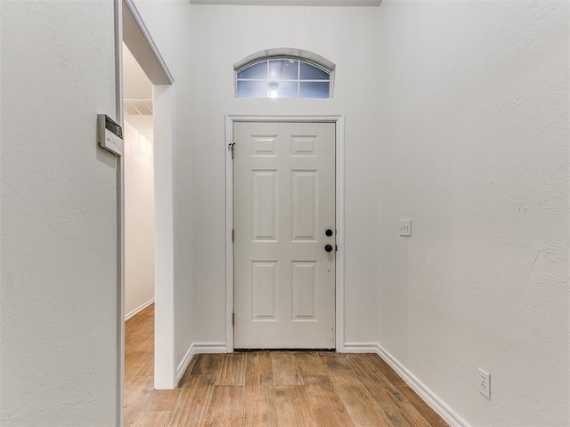 foyer entrance with light wood finished floors and baseboards