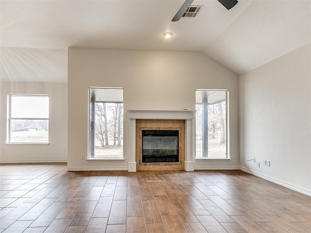 unfurnished living room featuring ceiling fan, lofted ceiling, a fireplace, visible vents, and baseboards