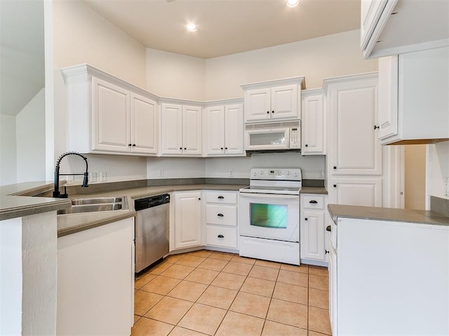 kitchen with light tile patterned floors, white appliances, a sink, and white cabinetry