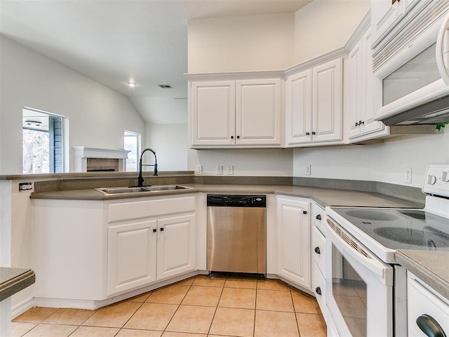 kitchen featuring light tile patterned floors, lofted ceiling, white cabinets, a sink, and white appliances