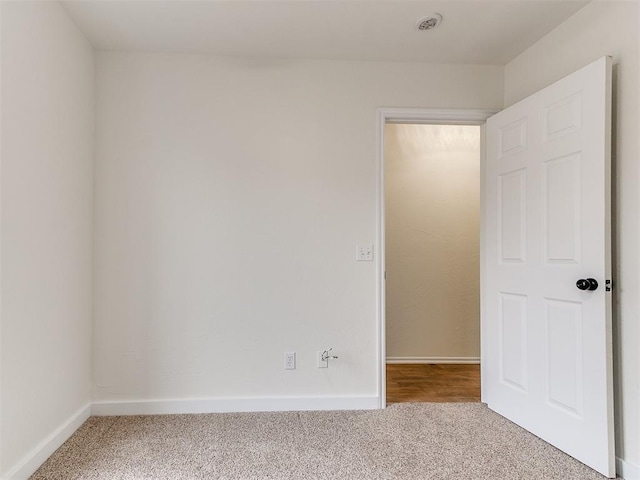 spare room with carpet and baseboards