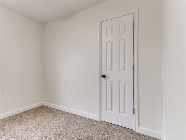 empty room featuring baseboards and carpet flooring