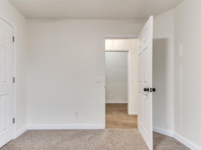 unfurnished bedroom featuring carpet and baseboards