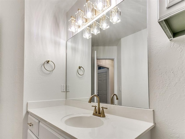 bathroom with vanity and a textured wall