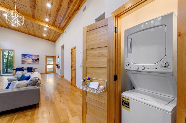 639 Woodland Hills Trl, Broken Bow, OK 74728 - clothes washing area with stacked washer and dryer, wood ceiling, a towering ceiling, a notable chandelier, and wood-type flooring