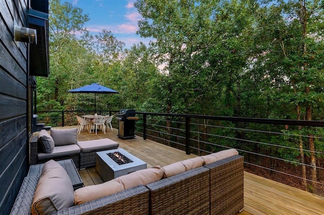 639 Woodland Hills Trl, Broken Bow, OK 74728 - deck at dusk featuring a grill and an outdoor living space with a fire pit
