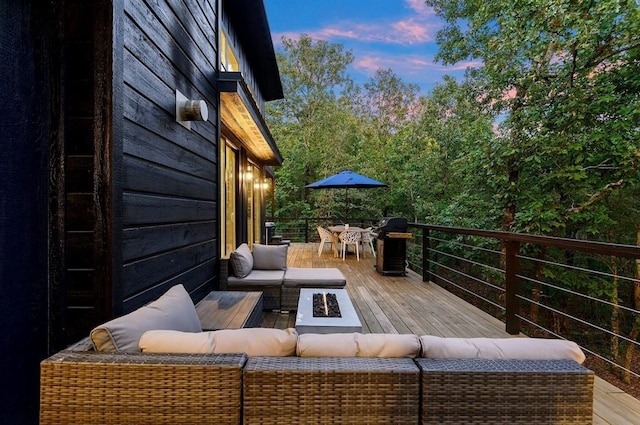 639 Woodland Hills Trl, Broken Bow, OK 74728 - deck at dusk with grilling area and an outdoor living space with a fire pit