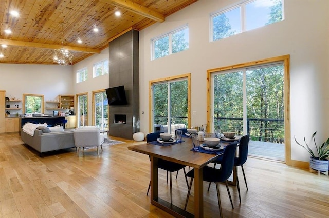 639 Woodland Hills Trl, Broken Bow, OK 74728 - dining area featuring a fireplace, wooden ceiling, light hardwood / wood-style floors, and beamed ceiling