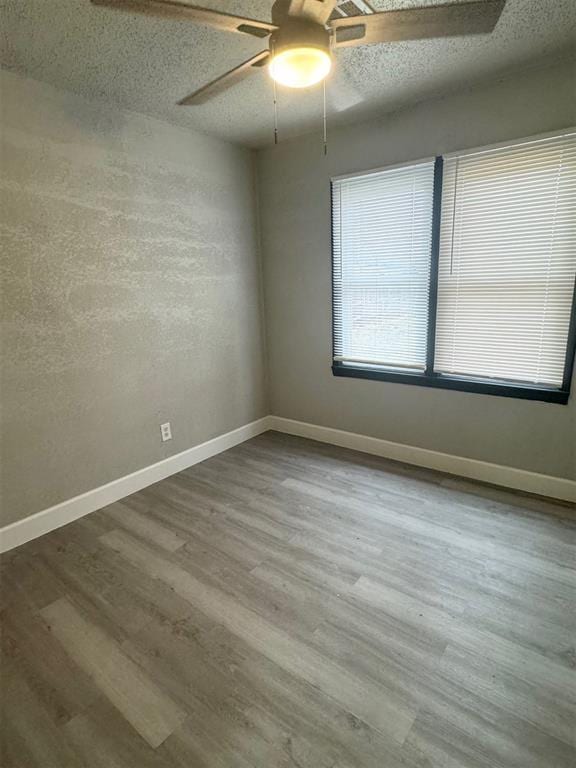 unfurnished room featuring wood-type flooring, ceiling fan, and a textured ceiling