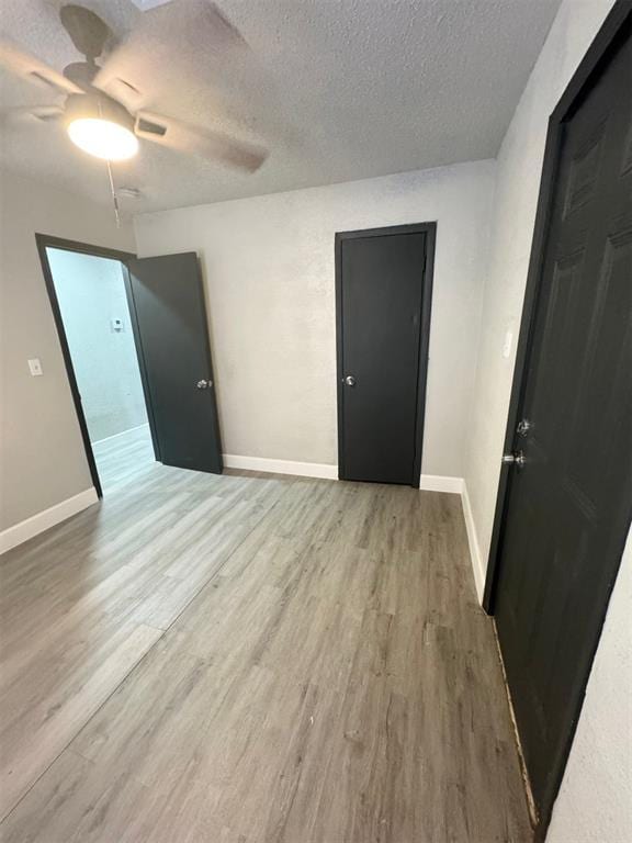 empty room with wood-type flooring, a textured ceiling, and ceiling fan