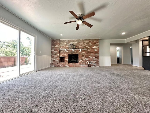 unfurnished living room featuring carpet floors, a fireplace, and a textured ceiling