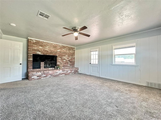 unfurnished living room featuring crown molding, ceiling fan, carpet, and a textured ceiling