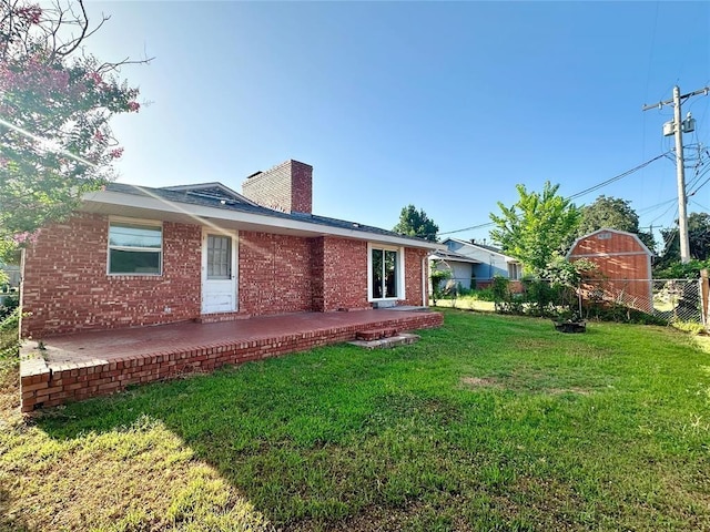 rear view of property with a lawn and a patio