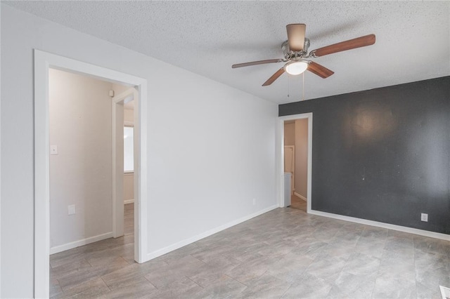 unfurnished room featuring ceiling fan and a textured ceiling