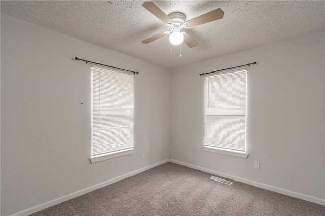 spare room with ceiling fan, carpet flooring, and a textured ceiling