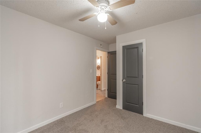 carpeted empty room featuring ceiling fan and a textured ceiling