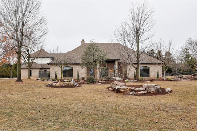 10401 Fawn Trace Rd, Mustang, OK 73064 - french country home featuring a front lawn, brick siding, and a chimney
