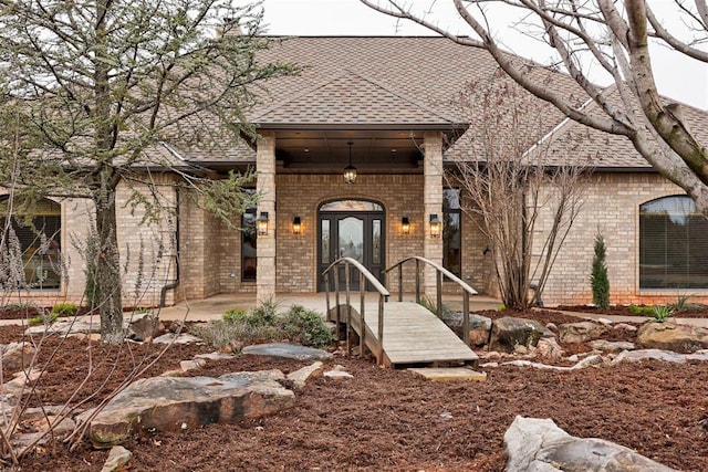 10401 Fawn Trace Rd, Mustang, OK 73064 - doorway to property featuring roof with shingles and brick siding