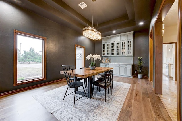 10401 Fawn Trace Rd, Mustang, OK 73064 - dining area featuring a tray ceiling, a textured wall, visible vents, light wood-style floors, and a chandelier