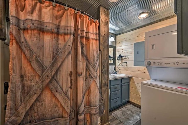 1985 Belpine Loop, Broken Bow, OK 74728 - bathroom featuring wooden walls, electric panel, stacked washer and clothes dryer, vanity, and wood-type flooring