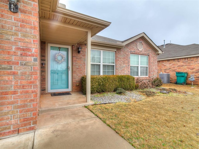 entrance to property with central AC unit and a yard