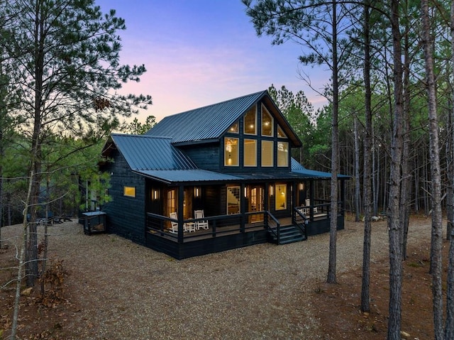 back house at dusk with a porch