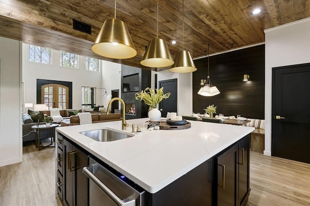 kitchen featuring sink, a kitchen island with sink, stainless steel dishwasher, wood ceiling, and french doors