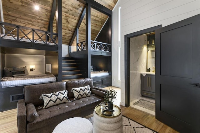 interior space with wood ceiling, light hardwood / wood-style flooring, high vaulted ceiling, and wood walls