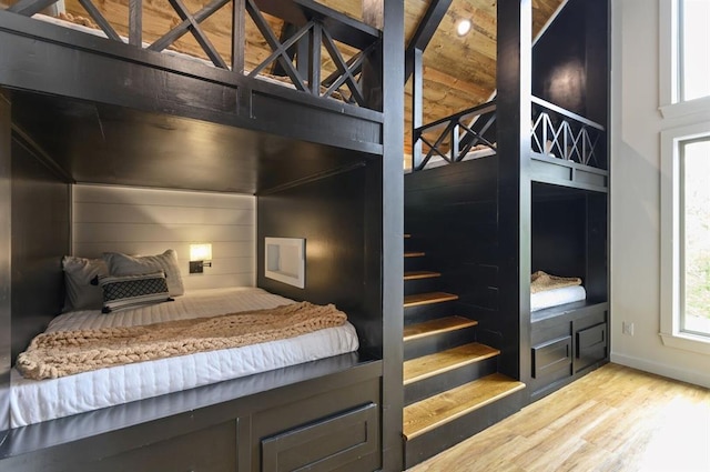 bedroom featuring wooden walls and light hardwood / wood-style flooring