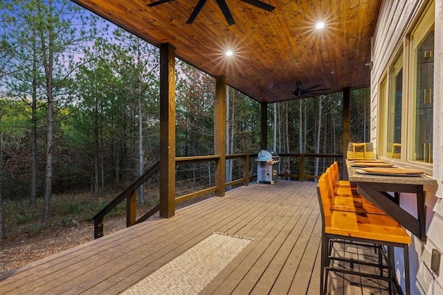 sunroom featuring ceiling fan and wooden ceiling