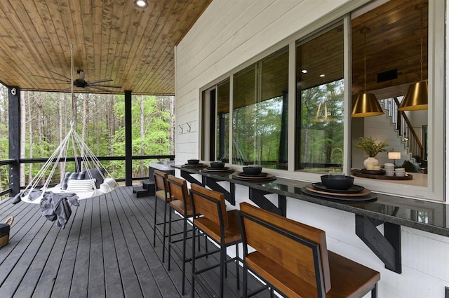 sunroom with ceiling fan and wood ceiling