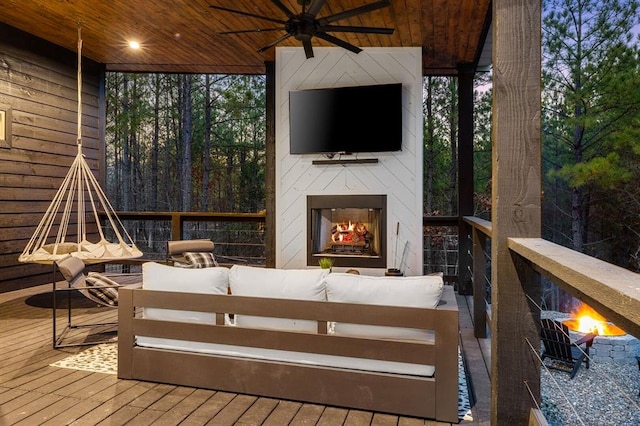 deck featuring an outdoor living space with a fireplace and ceiling fan