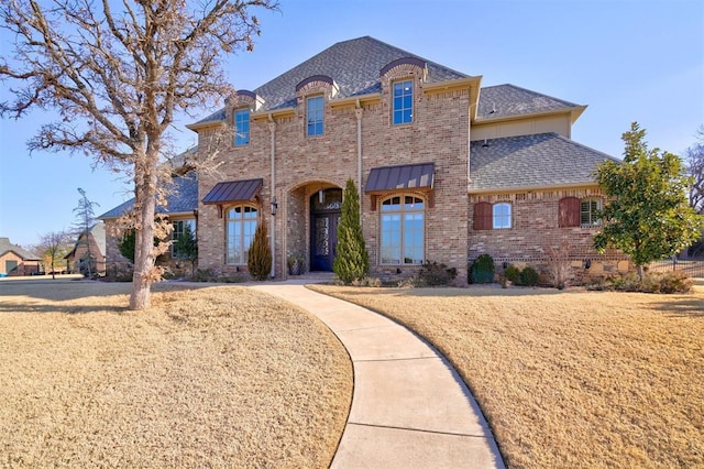 french provincial home with a front lawn