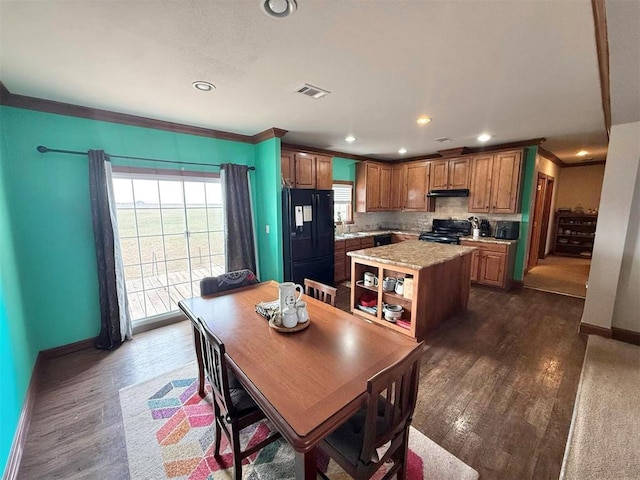 dining space with ornamental molding, visible vents, dark wood finished floors, and baseboards