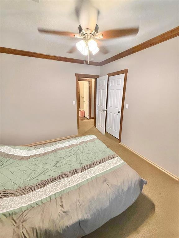 bedroom featuring ornamental molding, light carpet, baseboards, and a ceiling fan