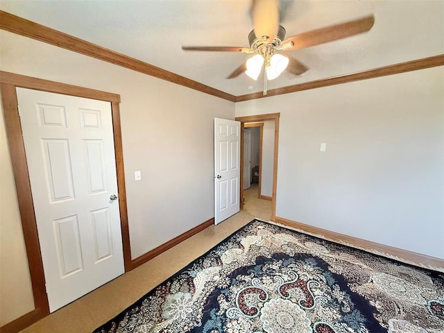 unfurnished room featuring ornamental molding, light carpet, ceiling fan, and baseboards