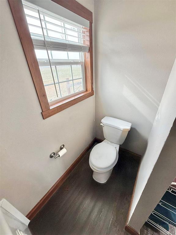 bathroom featuring wood finished floors, toilet, and baseboards